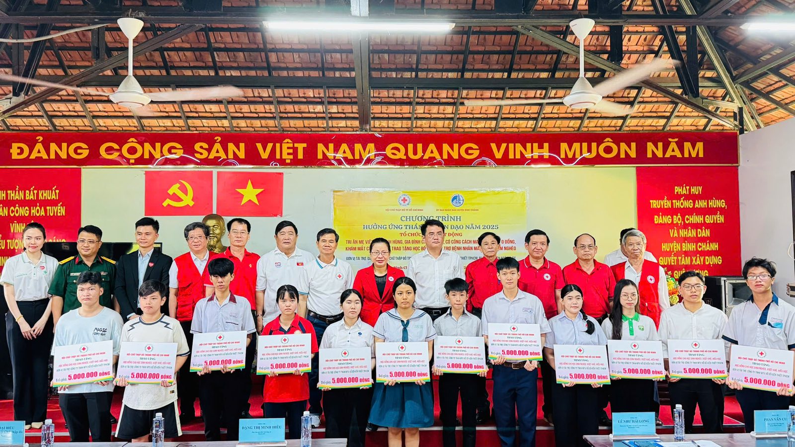 Lễ trao trợ cấp học tập của Hội Chữ thập đỏ Thành phố Hồ Chí Minh: học sinh nhận bảng trợ cấp cùng đại biểu trên sân khấu