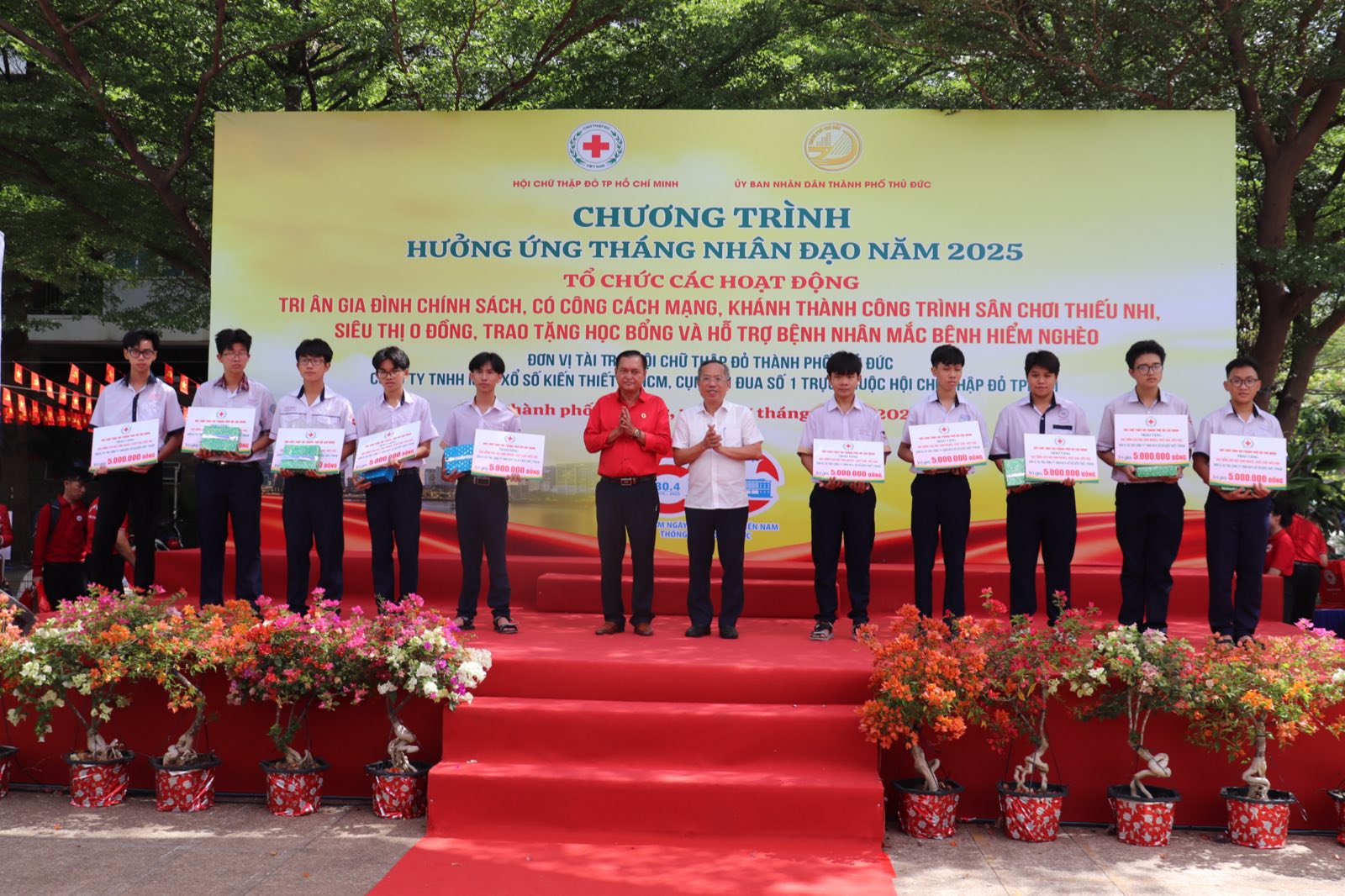 Đại biểu trao bảng tượng trưng trợ cấp học tập cho học sinh trên sân khấu chương trình